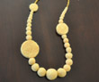 Strand of graduated-size yellow felt beads with felt discs and fresh water pearls