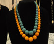 Long strand of graduated-size orange felt beads and long strand of graduated-size blue felt beads